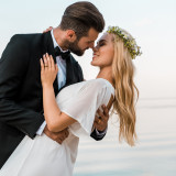 affectionate romantic wedding couple going to kiss on beach