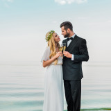 wedding couple clinking with glasses of champagne on beach and l