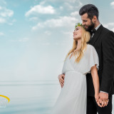 wedding couple in suit and white dress hugging on beach